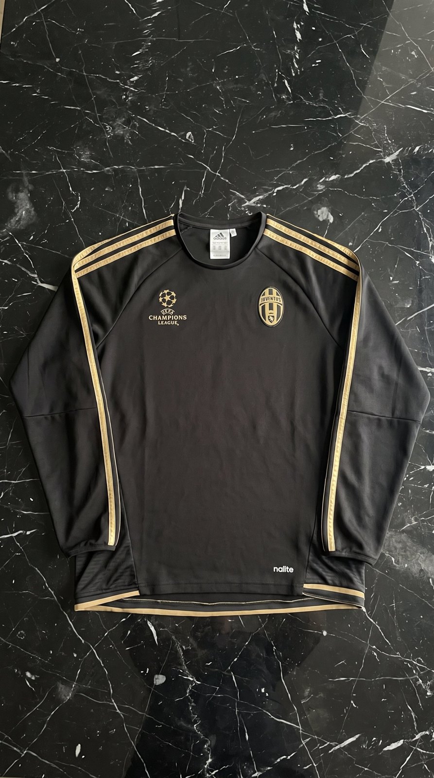 Le même maillot, à plat, repassé, sur un fond marbre noir